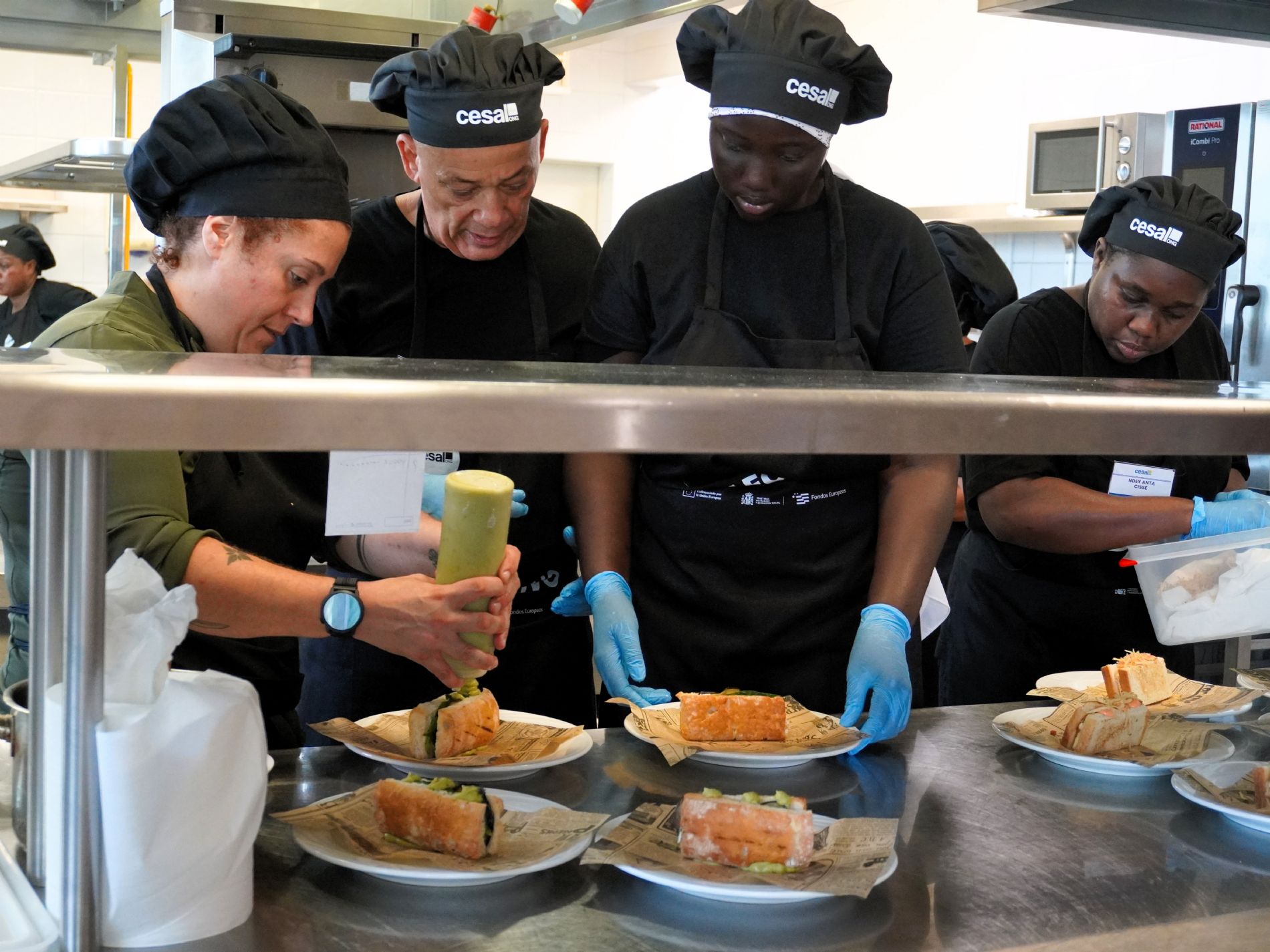 Patricia, docente de Cocina, acompa�a a participantes de Ayudante de Cocina de Empleo Vivo durante la preparaci�n de los platos en el brunch celebrado por Cesal en Tenerife Sur. / Foto: Cesal