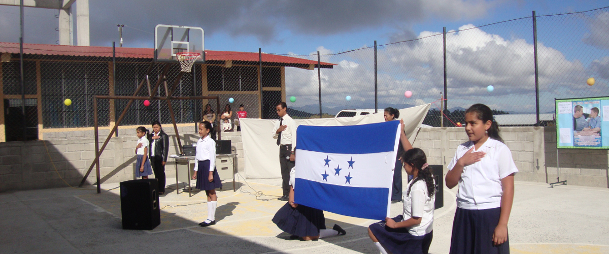 Foto niños haciendo honores a la bandera